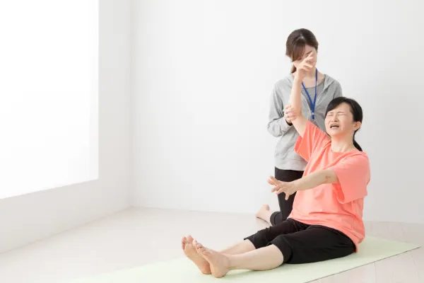 一人では腕が上がらない様子